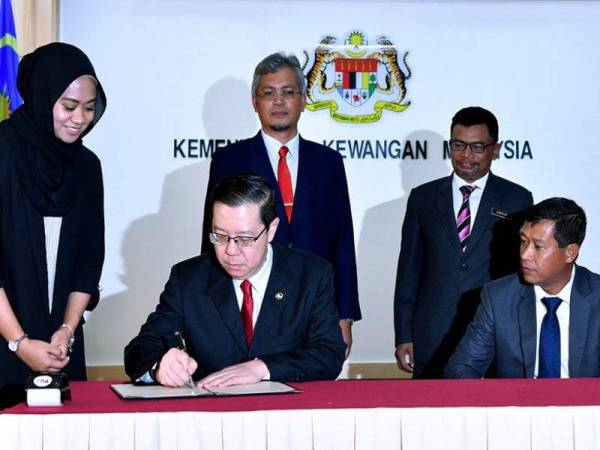 Menteri Kewangan Lim Guan Eng (duduk kiri) menandatangani perjanjian utama Program Kolaborasi Industri (ICP) dengan Bombardier Hartasuma Consortium (BHC) berkaitan kontrak membekal dan memperbaharui kereta api bagi Prasarana Malaysia Berhad di Kementerian Kewangan hari ini. Majlis disaksikan Timbalan Ketua Setiausaha Kementerian Kewangan Datuk Asri Hamidon (duduk, kanan), Ketua Pegawai Eksekutif Teknology Depository Agency Berhad (TDA) Datuk Zailani Safari dan Setiausaha Bahagian Perolehan Kementerian Kewangan Datuk Zamzuri Abdul Aziz (berdiri kanan). - Foto Bernama
