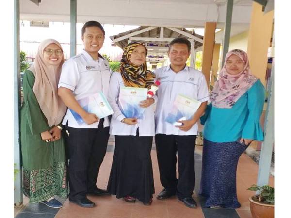 Md Yusof (dua dari kanan ), Jabarah Daiman (tengah) dan Syafiq selepas penyampaian APC di SMK Dato Penggawa Barat, kelmarin.