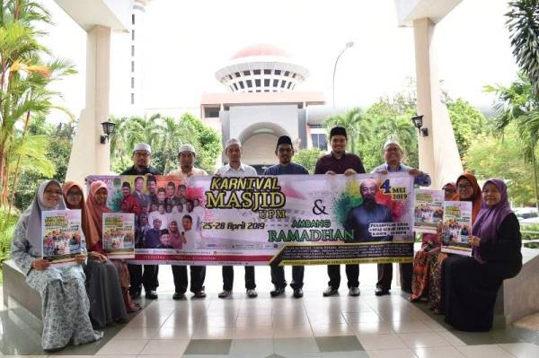 Mat Razi (berdiri, tiga, kanan) dan Ustaz Alzasha Iliyyin (berdiri, tiga, kiri) bersama ahli jawatankuasa penganjur mempromosikan Karnival Masjid UPM yang akan berlangsung di pekarangan Masjid UPM di Serdang selama empat hari mulai esok