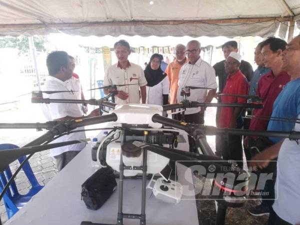 Zulkepli (dua kiri) melihat dron untuk kegunaan meracun padi yang dipamerkan pada Hari Bertemu Pelanggan MOA Inc di Gong Nering.