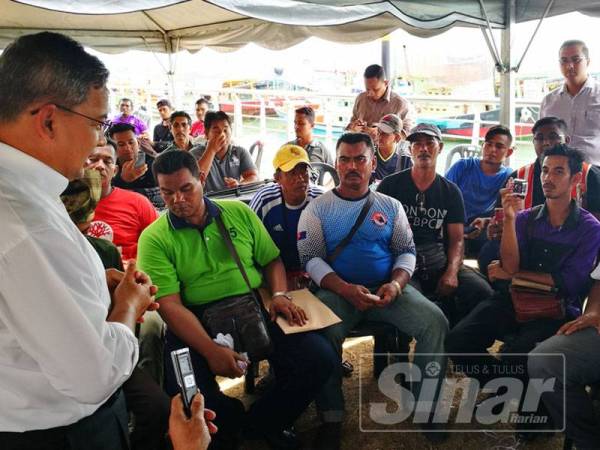 Azman (kanan) bertemu kumpulan nelayan yang mengadakan bantahan secara aman menentang pencerobohan nelayan asing di perairan negara yang diadakan di muara Sungai Terengganu, hari ini.