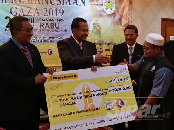 Wakil Iman Care & Warga Cakna (dua kanan) menyerahkan sumbangan kepada Ahmad Samsuri (dua kiri), sambil diperhatikan Pengarah PAS Relief, Muhammad Sanusi Md Nor (kiri).