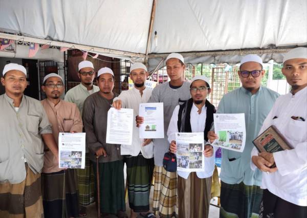 Tenaga pengajar Madrasah Ribat Al-Musthofa membuat laporan polis di IPD Machang di sini, hari ini.