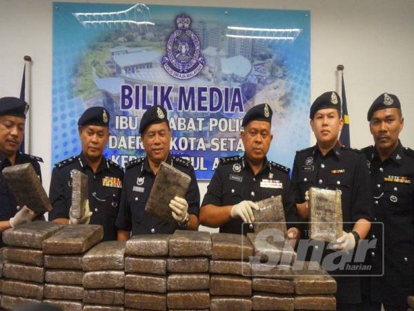 Kamarulzaman (tiga dari kanan) menunjukkan sebahagian ketulan dadah mampat dirampas pada sidang media di Bilik Media Ibu Pejabat Polis Daerah (IPD) Kota Setar, di sini, hari ini.
