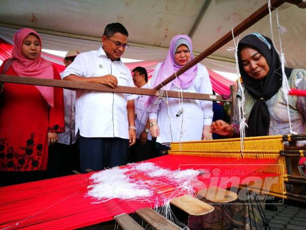 Rina (kanan) diiringi Dr Azman dibawa melawat tapak pameran sempena KUD Zon Timur.