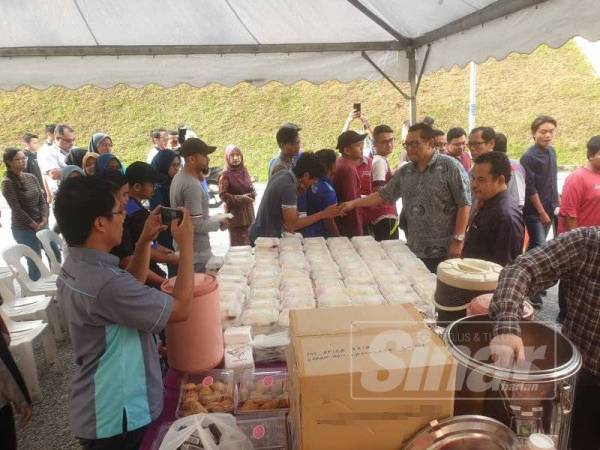 Zaini dan Dr Azizan (kiri) mengedarkan bungkusan sarapan kepada para pelajar UiTM Shah Alam selepas melancarkan program agihan makanan di Kolej Kediaman Delima 2, Shah Alam semalam. - Foto Sinar Harian 