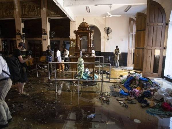 Wartawan mengambil gambar dalam Gereja St. Anthony di Colombo yang menjadi antara lokasi sasaran siri pengeboman yang mengorbankan lebih 250 nyawa pada 21 April lalu. - Foto AFP