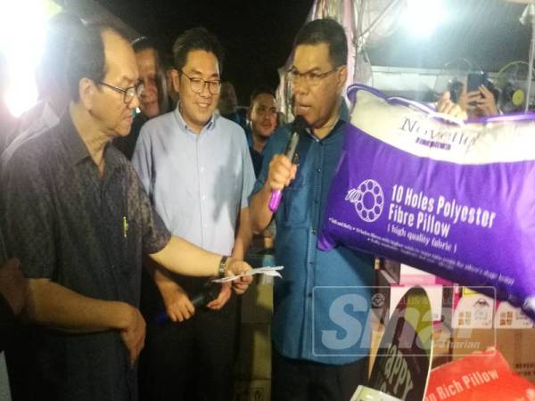 Saifuddin (kanan) membuat lelongan bantal buatan tempatan yang dijual pada Kempen Beli Barangan Buatan Malaysia yang diadakan malam tadi.