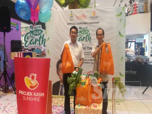 Tze Tzin (kiri) bersama Kam Ming ketika melancarkan kempen selamatkan bumi bersempena Projek Kasih Sunshine di Pasaraya Sunshine, semalam.