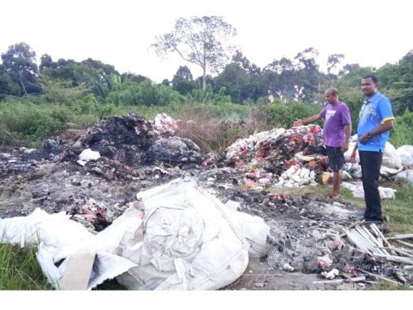 Yogeswaran (kanan) melihat tempat pembuangan sampah haram di Mantin semalam.