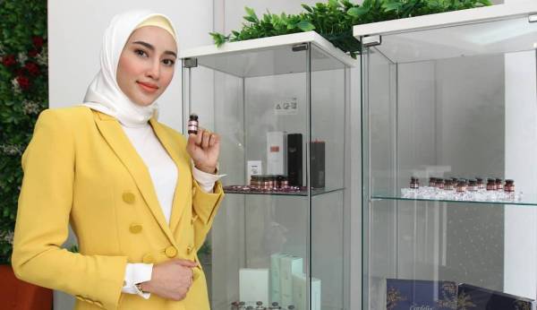 Eira bersama produk Ruby-Cell yang berfungsi membantu merawat kulit wajah wanita