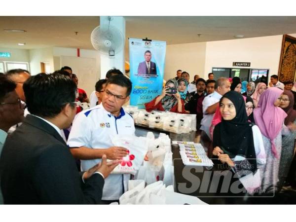 Saifuddin mengagihkan pek makanan kepada pelajar golongan B40 pada pelancaran Food Bank Siswa Malaysia di UniSZA.