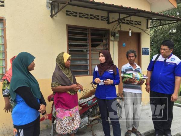 Baharudin (kanan) ketika menyampaikan sumbangan di rumah Nurfarahin (kiri) di Kampung Orang Asli Redang Punggor.