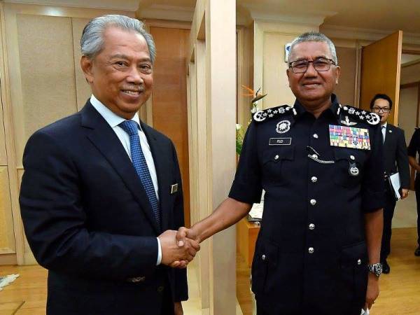 Menteri Dalam Negeri, Tan Sri Muhyiddin Yassin bersalaman dengan Tan Sri Mohamad Fuzi Harun semasa menerima kunjungan hormat perpisahan Ketua Polis Negara itu di pejabatnya di Kementerian Dalam Negeri hari ini. - Foto Bernama