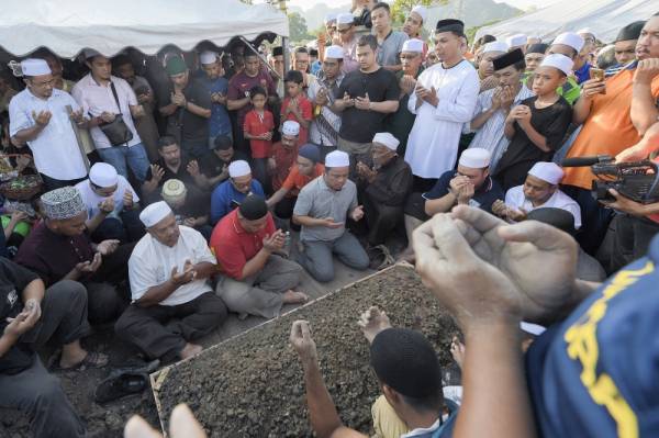 Ahli keluarga dan kenalan mengaminkan bacaan doa selepas jenazah Allahyarham Datuk Seri Abu Hassan Din Al Hafiz setelah selamat dikebumikan di Tanah Perkuburan Raudatul Sakinah hari ini. -Foto Bernama