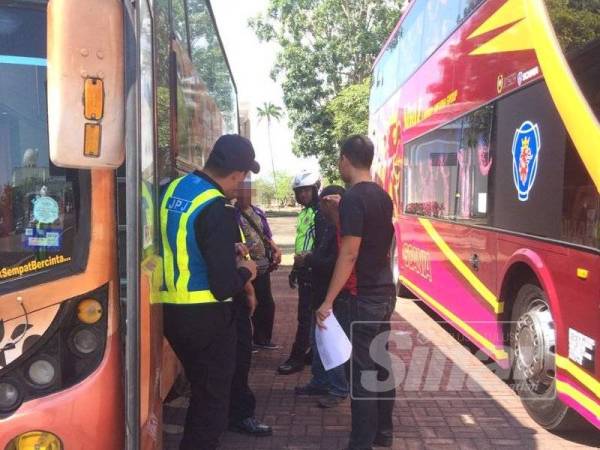 Anggota JPJ melakukan pemeriksaan ke atas salah sebuah bas persiaran di antara lokasi tumpuan pelancong sempena Ops Khas Bas Persiaran, semalam.