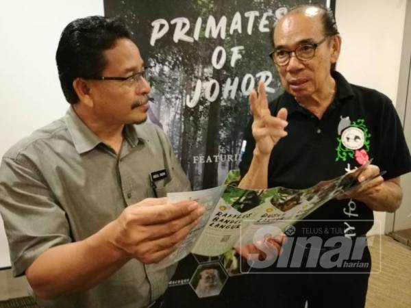 Vincent memberi penerangan kepada Abdul Razak tentang brosur berkaitan primat yang bakal diedarkan di sekolah pada majlis Pelancaran Brosur Primates of Johor hari ini.