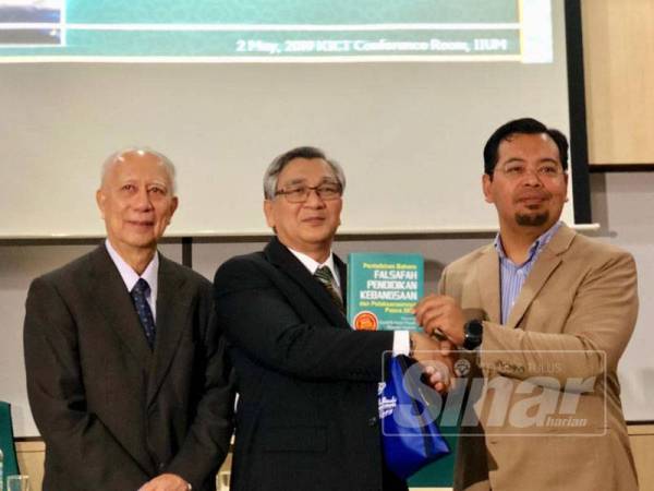 Mohamad Ariff (tengah) menerima buku daripada Zulkifli (kanan) sambil diiringi Syed Arabi pada Majlis Perasmian Seminar Pilihan Raya Umum ke-14 (PRU14) sempena setahun pentadbiran kerajaan Pakatan Harapan (PH) di Universiti Islam Antarabangsa Malaysia (UIAM) di sini hari ini.
