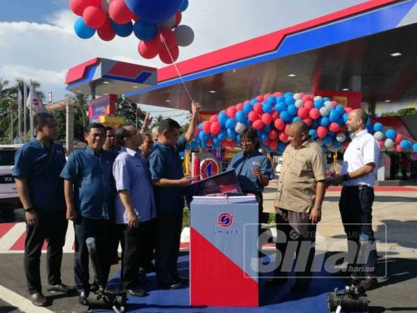 Saifuddin memotong belon sebagai simbolik perasmian stesen minyak Smart Stream di Felda Siantan Jengka 19 di sini hari ini.