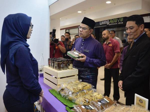 Saifuddin Nasution (dua, kiri) beramah mesra bersama peniaga ketika melawat tapak bazar ketika Majlis Perasmian Bazar Aidilfitri dan Bank Makanan Siswa di Universiti Teknologi Malaysia (UTM) hari ini. - Foto Bernama
