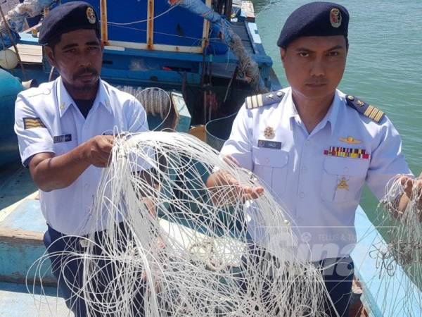 Rashidilhadi (kanan) dan pegawainya mrnunjukkan rawai yang dirampas dari salah sebuah bot yang ditahan.