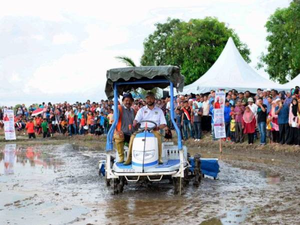 Menteri Besar Kedah Datuk Seri Mukhriz Tun Mahathir yang juga Pengerusi MADA membawa jentera menabur padi pada Program Jom Turun Bendang MADA di Jalan Pulau Bunting, Kampung Sungai Kering Dulang hari ini. - FOTO BERNAMA