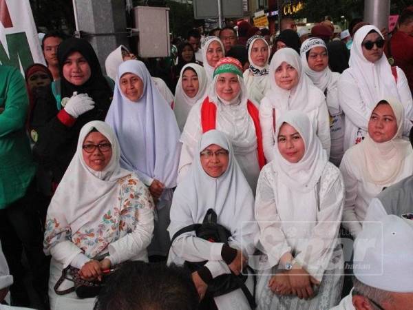 Noraini (dua kanan) bersama peserta wanita lain yang turut serta dalam Himpunan Pertahan Kedaulatan Islam di Kuala Lumpur hari ini.