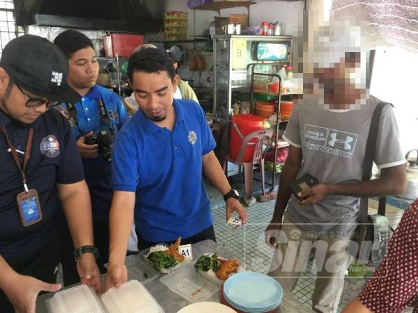 Seorang warga Pakistan (kanan) dikesan ketika sedang memesan makanan di sebuah gerai di Bukit Rambai pada hari pertama Ops Ramadan, hari ini.