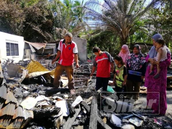 Keluarga mangsa melihat keadaan rumah pusaka yang hangus dalam kejadian, petang semalam.