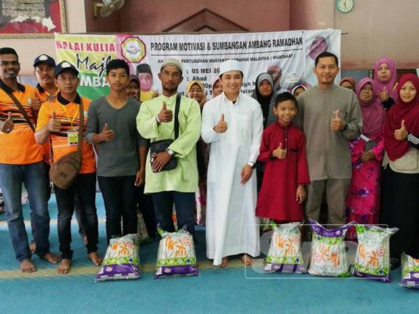 Adam (tengah) bersama sebahagian besar penerima sumbangan program Ihya Ramadan yang terdiri 50 golongan asnaf sekitar Parlimen Bagan Serai.