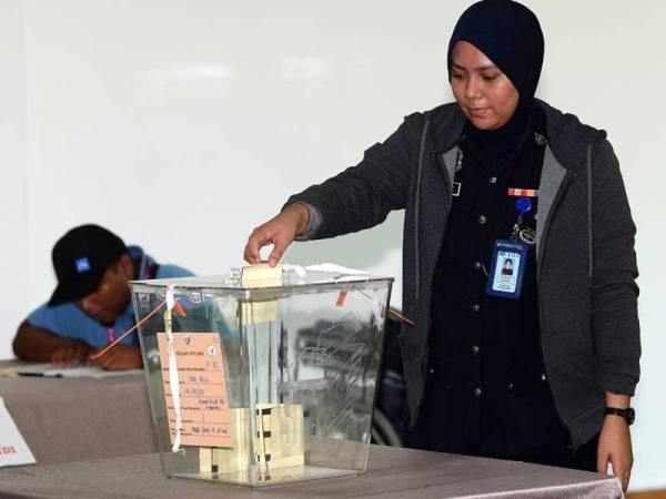 Anggota polis mengundi awal bagi Pilihan Raya Kecil (PRK) Parlimen Sandakan pusat pengundian awal di Rumah Kelab Ibu Pejabat Polis Daerah (IPD) Sandakan pagi ini. - Foto Bernama