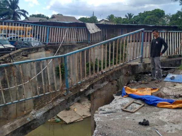 Zainuddin meninjau keadaan hakisan pada sistem saliran berkenaan.