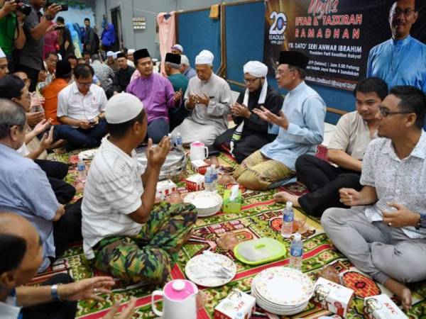 Anwar (tiga, kanan) diiringi Pengerusi Masjid Nurussyakirin Taman Indah Jaya, Mulyadi Kasimin (empat, kanan) pada program Berbuka puasa hari ini. Sebelum itu, pelbagai program diadakan seperti sesi tazkirah dan menandatangani plak cenderahati khat. -Foto Bernama