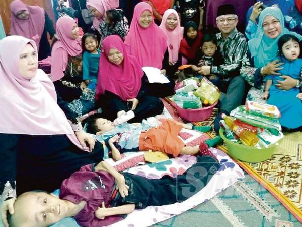 Adham (tiga dari kanan) ketika hadir program Semarak Kasih Ramadhan bagi Menyantuni Anak-anak Istimewa Johor@Anak-anak Syurga di Balai Raya SS7 Taman Sri Saujana kelmarin. 