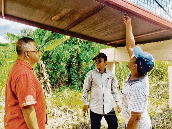 Mohd Anuar (tengah) melawat Jambatan Gantung Sungai Dingin dekat Kampung Mambang Berulang yang rosak. 