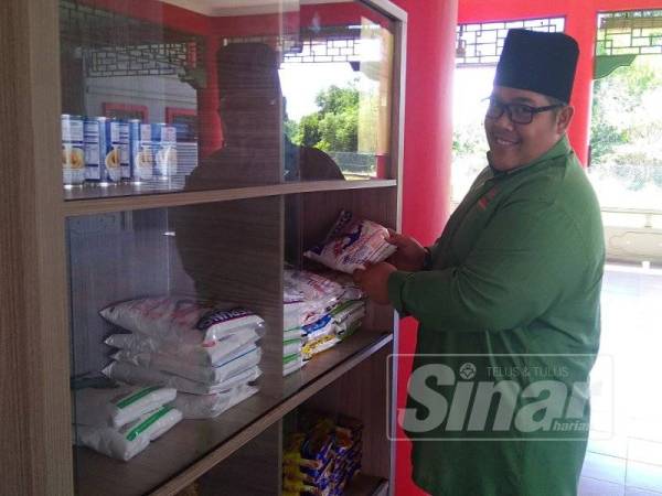 Murad sedang menyusun barang makanan yang disumbangkan individu untuk diambil oleh mereka yang memerlukan.