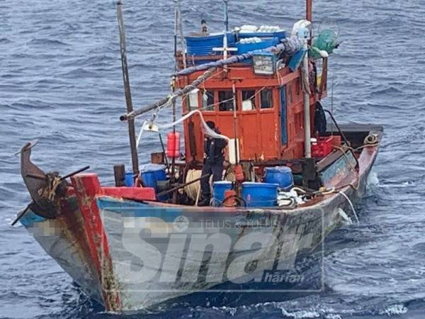 Penguat kuasa Maritim Malaysia memeriksa bot Vietnam yang ditahan pada jarak lebih kurang 101 batu nautika dari Kuala Kemaman.- Foto arkib Sinar Harian