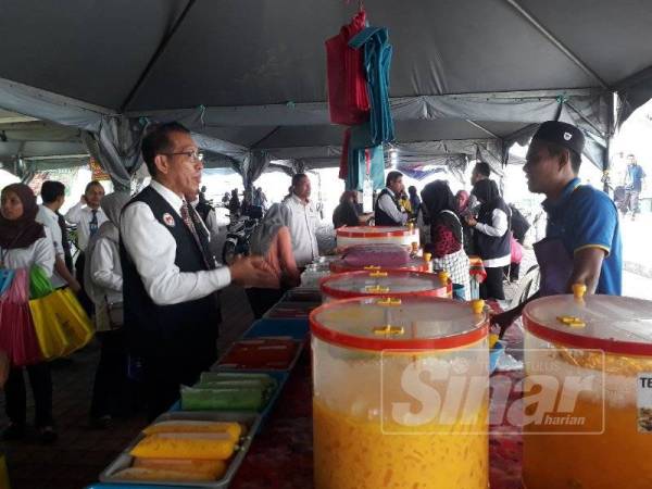 Dr Norhizan (kiri) sempat bertanya khabar kepada penjual makanan di Bazar Ramadan Pokok Sena sempena kunjungannya untuk tujuan pemeriksaan dan promosi keselamatan makanan hari ini.