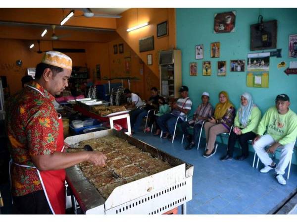 Pemilik Murtabak Mawar Datuk Tun Mohamad Aidil Razali,38, menyiapkan pesanan para pelanggan yang sabar menunggu walaupun terpaksa beratur bagi dijadikan juadah berbuka puasa ketika tinjauan hari ini. - Foto Bernama