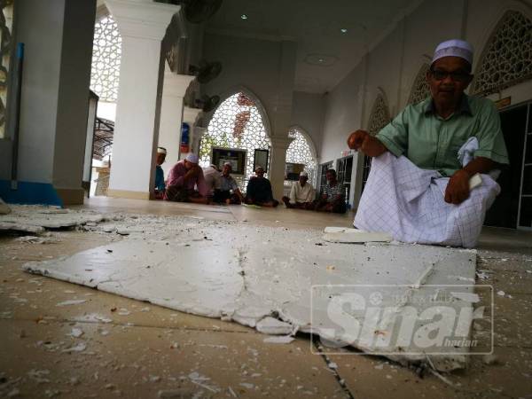 Isa menunjukkan siling yang runtuh di Masjid Pengkalan Barangan.