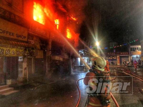 Anggota bomba sedang memadamkan kebakaran yang melibatkan tujuh buah kedai di Jalan Kuala Kangsar, Prangin Estate di sini, kira-kira jam 2.30 pagi tadi.