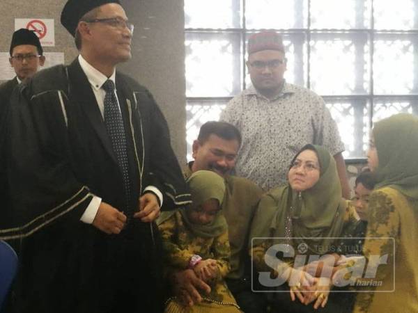 Yusnidah (kiri) berbincang bersama peguam syarie Mahyuddin Md Zahari selepas prosiding selesai hari ini.