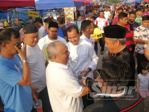 Asyraf dan Mat Nadzari beramah mesra dengan pengunjung bazar ketika mengagihkan sumbangan kurma