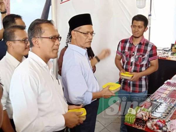 Mohd Zain (kiri) dan Dr Shahruddin (tengah) mengagihkan bubur lambuk percuma di Bazar Ramadan Jalan Raja dan Dataran Merdeka, hari ini.