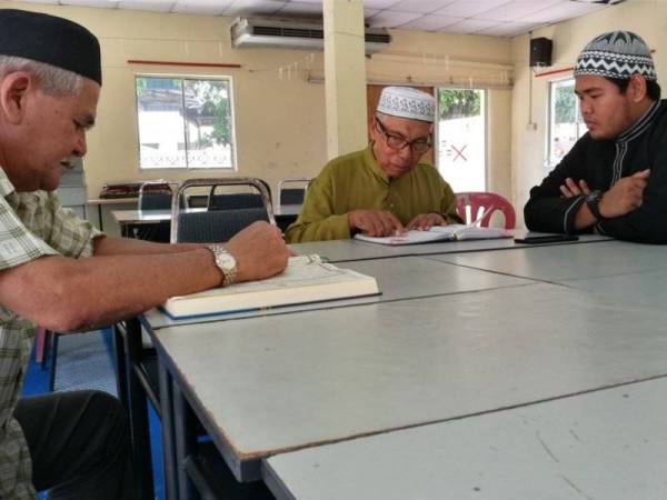 Mohamad Hamdani (kanan) menyemak bacaan al-Quran dalam kelas yang diadakan di Masjid Muhammadiah.