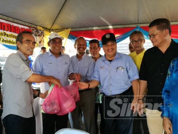 Abd Rahim (dua dari kiri) diiringi Fadzilla (tiga dari kanan) menerima makanan daripada peniaga di bazar Mahkota Squere selepas merasmikan Wakaf Infaq Ramadan, di sini, semalam.