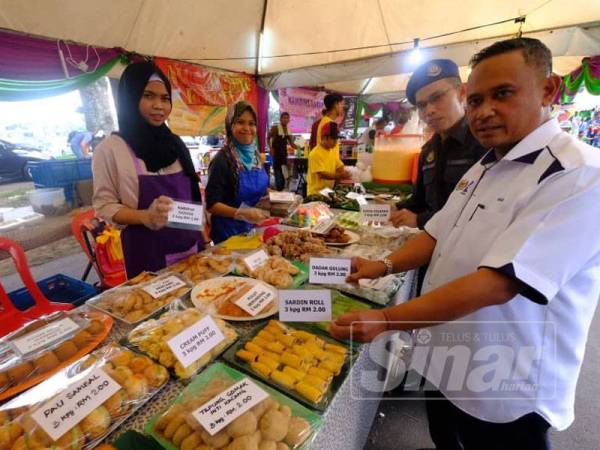 Mohd Hairul Anuar (kanan) menunjukkan tanda harga yang dipamerkan salah seorang peniaga ketika membuat lawatan di Bazar Ramadan Plaza Angsana di sini hari ini.