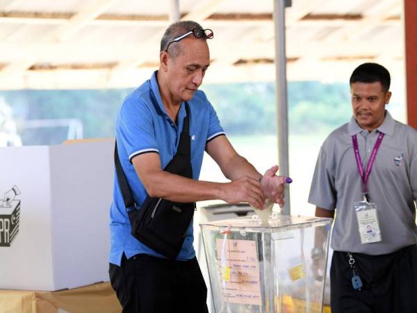 Pengundi pertama, Ahmad Kulambong, 60, memasukkan kertas undinya ke dalam peti undi sewaktu mengundi pada Pilihan Raya Kecil Parlimen Sandakan di Pusat Pengundian Sekolah Kebangsaan (SK) Muhibbah hari ini. - Bernama
