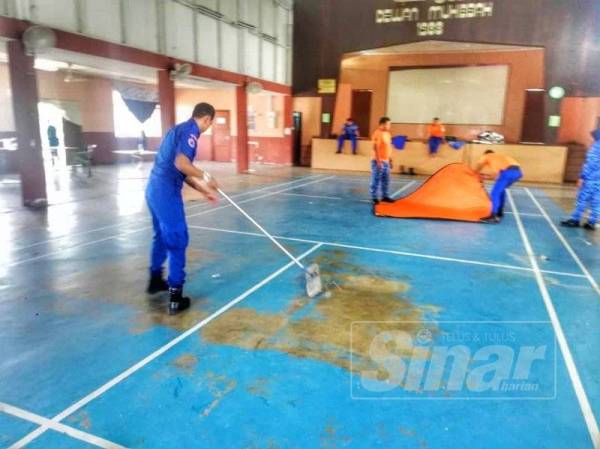 Anggota Angkatan Pertahanan Awam sedang membersihkan Dewan Muhibbah selepas pusat pemindahan banjir tersebut ditutup petang tadi.