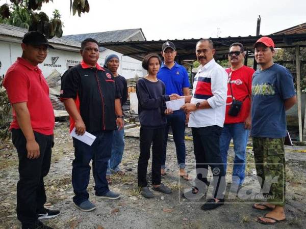 Abu Bakar Yahya (tiga dari kanan) menyerahkan sumbangan kepada Mohd Azman semalam.